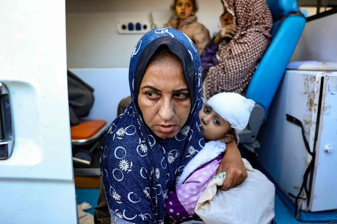 Women and children injured during an Israeli strike wait in front of the Al-Aqsa Martyrs hospital in central Gaza.