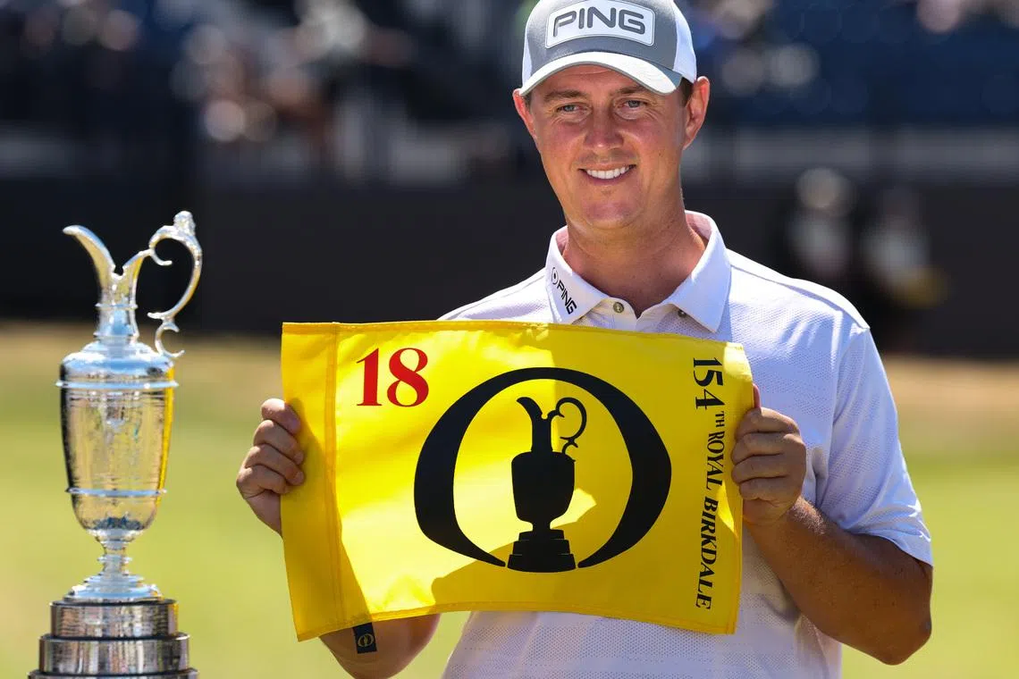 Jul 13, 2026; Southport, England; Joe Dean poses with an eighteenth hole flag alongside the Claret Jug as he wins the Last Qualifier for The Open Championship golf tournament at Royal Birkdale. Mandatory Credit: Bill Streicher-Imagn Images