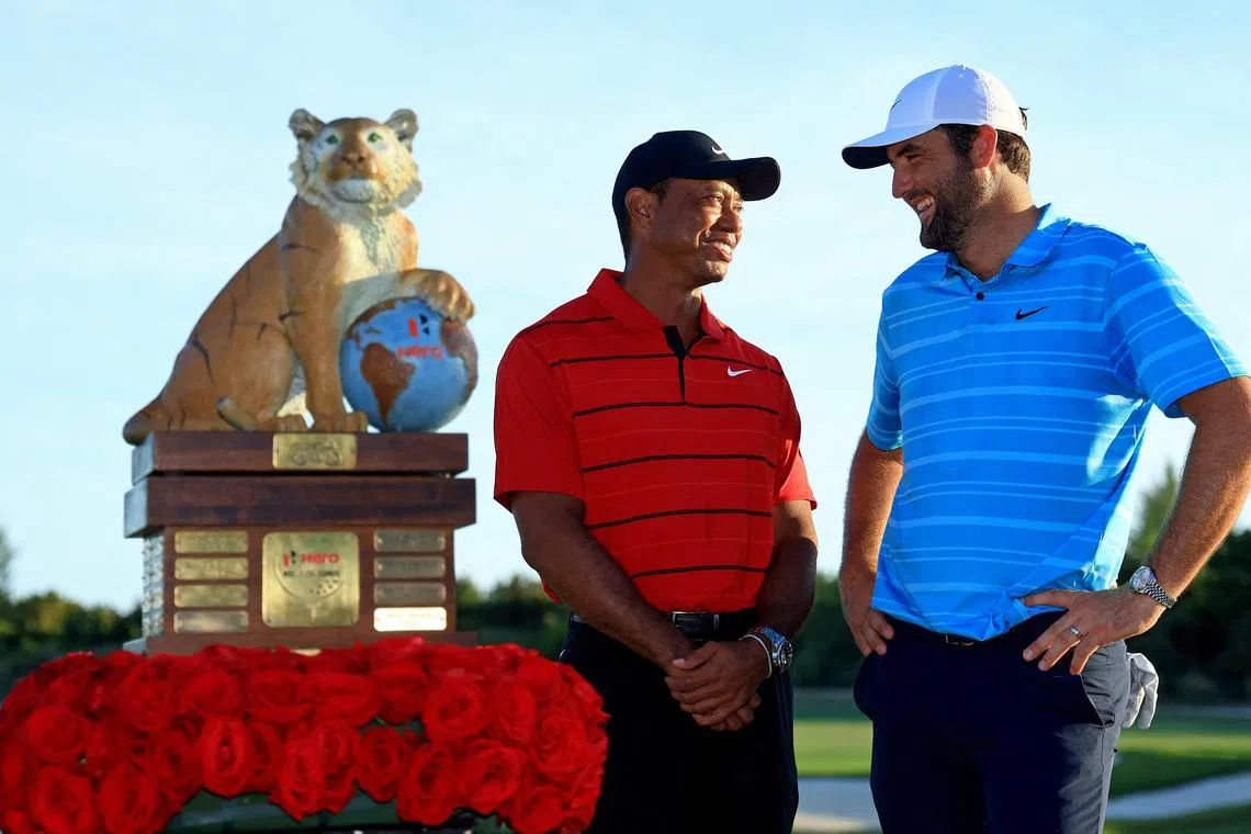 Scottie Scheffler and tournament host Tiger Woods posing with the trophy after the final round of the Hero World Challenge.