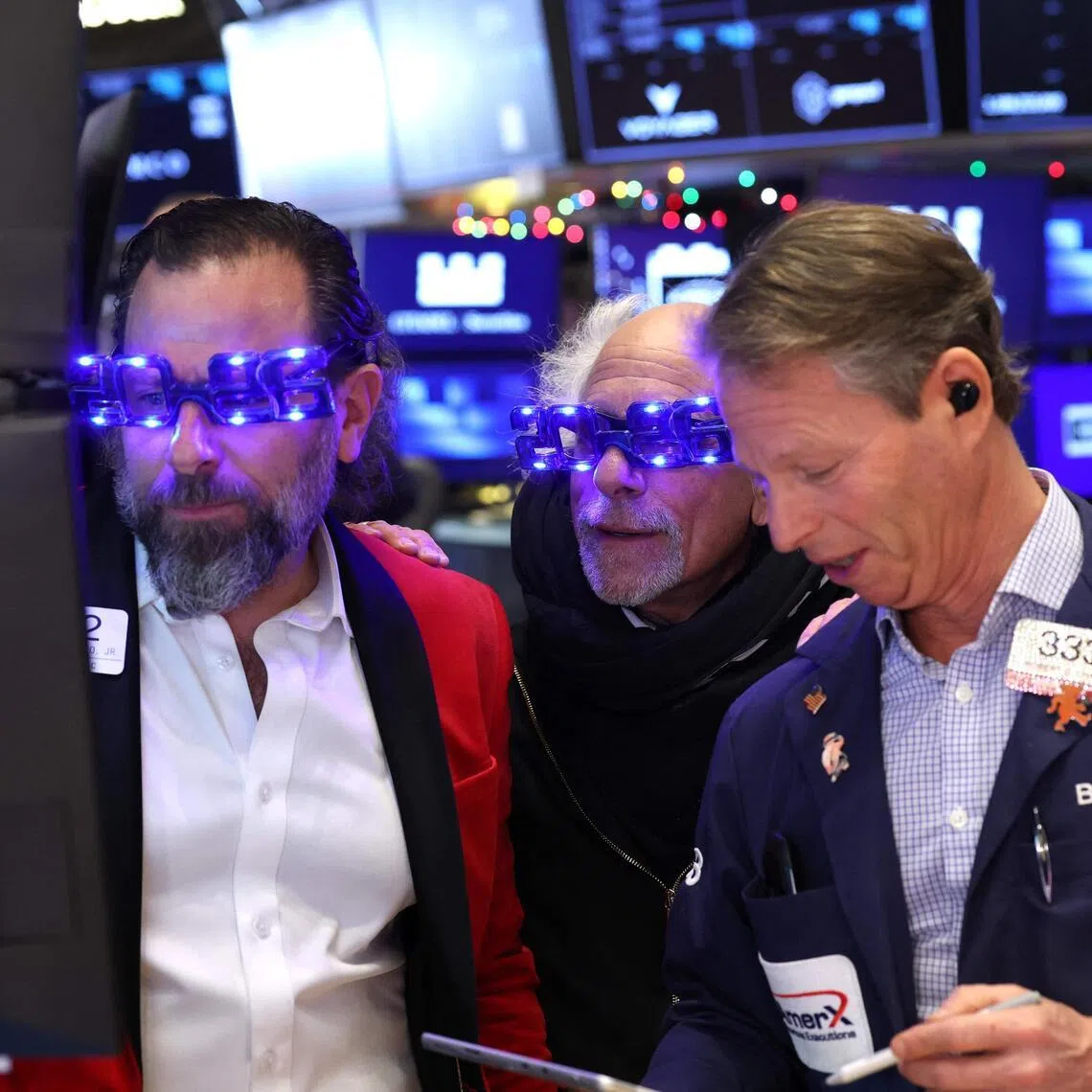 Traders wearing "2026" glasses working on the floor of the New York Stock Exchange on Dec 31, in New York City.
