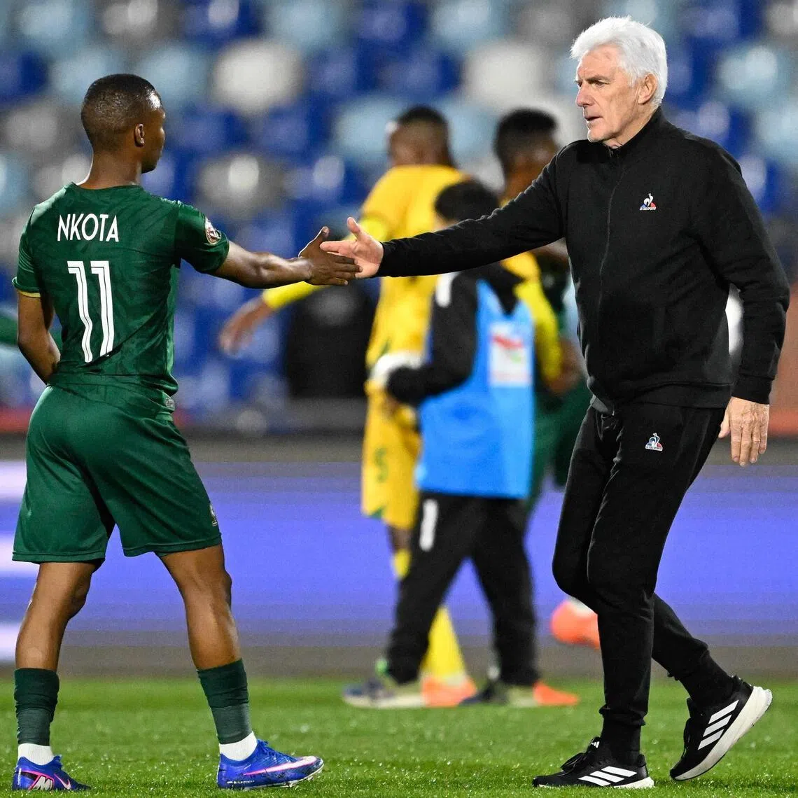 South Africa coach Hugo Broos shakes hands with midfielder Mohau Nkota after the Africa Cup of Nations match against Zimbabwe.