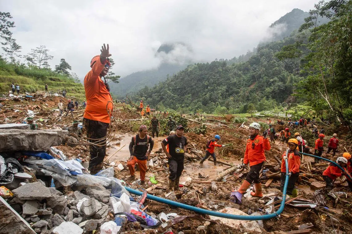 Rescue teams, including Indonesia's National Search and Rescue Agency (BASARNAS), the army, police, and volunteers, use high-pressure water to search for victims of a landslide triggered by heavy rain two days ago, which has so far claimed 19 lives, in Kasimpar Village, Central Java, on January 22, 2025. Hundreds of rescuers were searching through thick mud and debris to find survivors January 22 after a rain-triggered landslide in Indonesia killed at least 19 people and left seven missing. (Photo by DEVI RAHMAN / AFP)