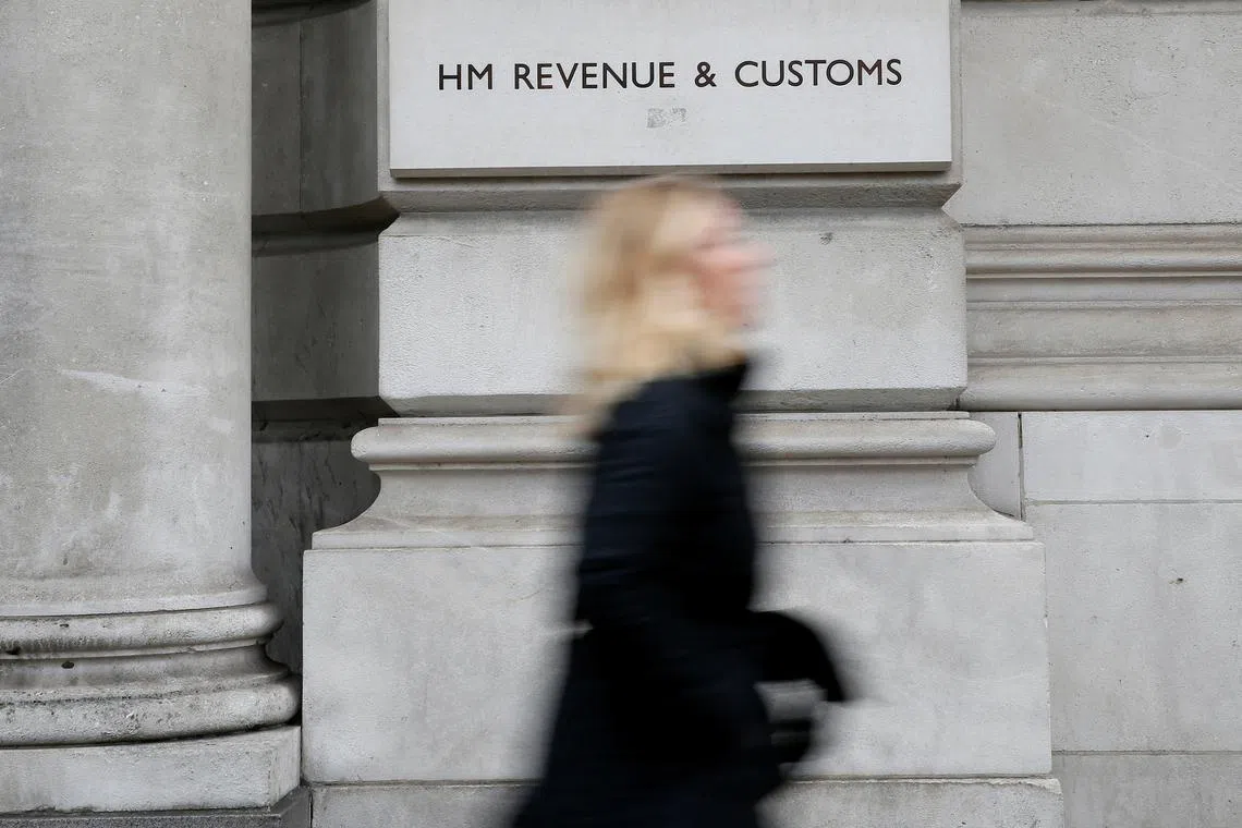 FILE PHOTO: A pedestrian walks past the headquarters of Her Majesty's Revenue and Customs (HMRC) in central London February 13, 2015.  REUTERS/Stefan Wermuth/File Photo