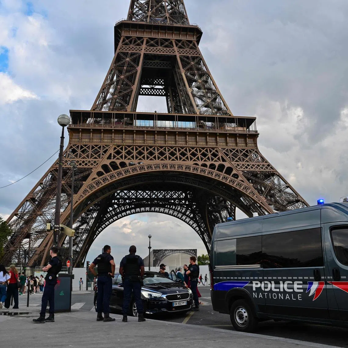 (FILES) French police officers patrol in front of the Eiffel tower in Paris on September 13, 2023. Security, transport, summer bonuses: organizers and the state still have their work cut out to ensure that the Paris Olympics run smoothly in summer 2024. (Photo by MIGUEL MEDINA / AFP)