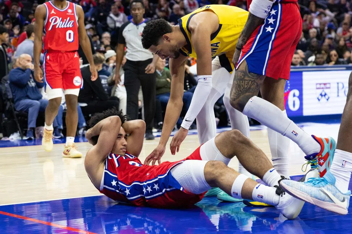 Dec 13, 2024; Philadelphia, Pennsylvania, USA; Philadelphia 76ers guard Jared McCain (20) holds his head next to Indiana Pacers guard Tyrese Haliburton (0) after a hard fall during the third quarter at Wells Fargo Center. Mandatory Credit: Bill Streicher-Imagn Images