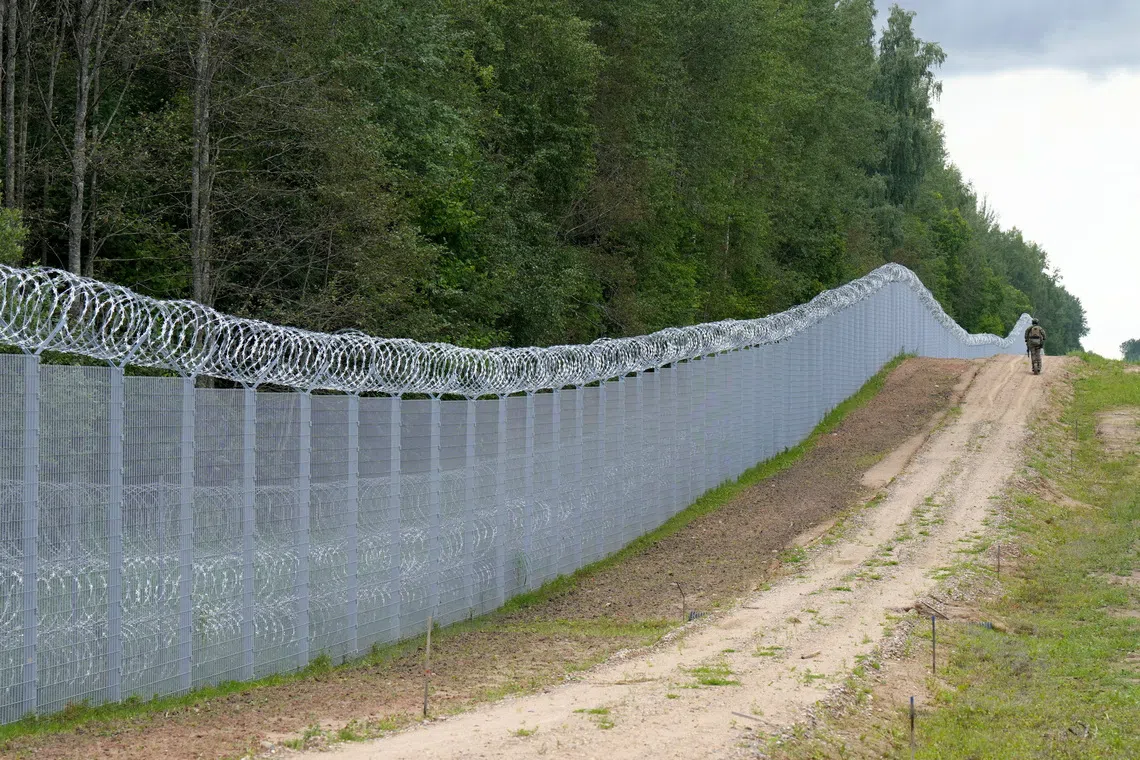 Latvian special unit Border Guard officer patrols along the fence at Latvian-Belarus border near Robeznieki, Latvia August 8, 2023. REUTERS/Ints Kalnins/File Photo