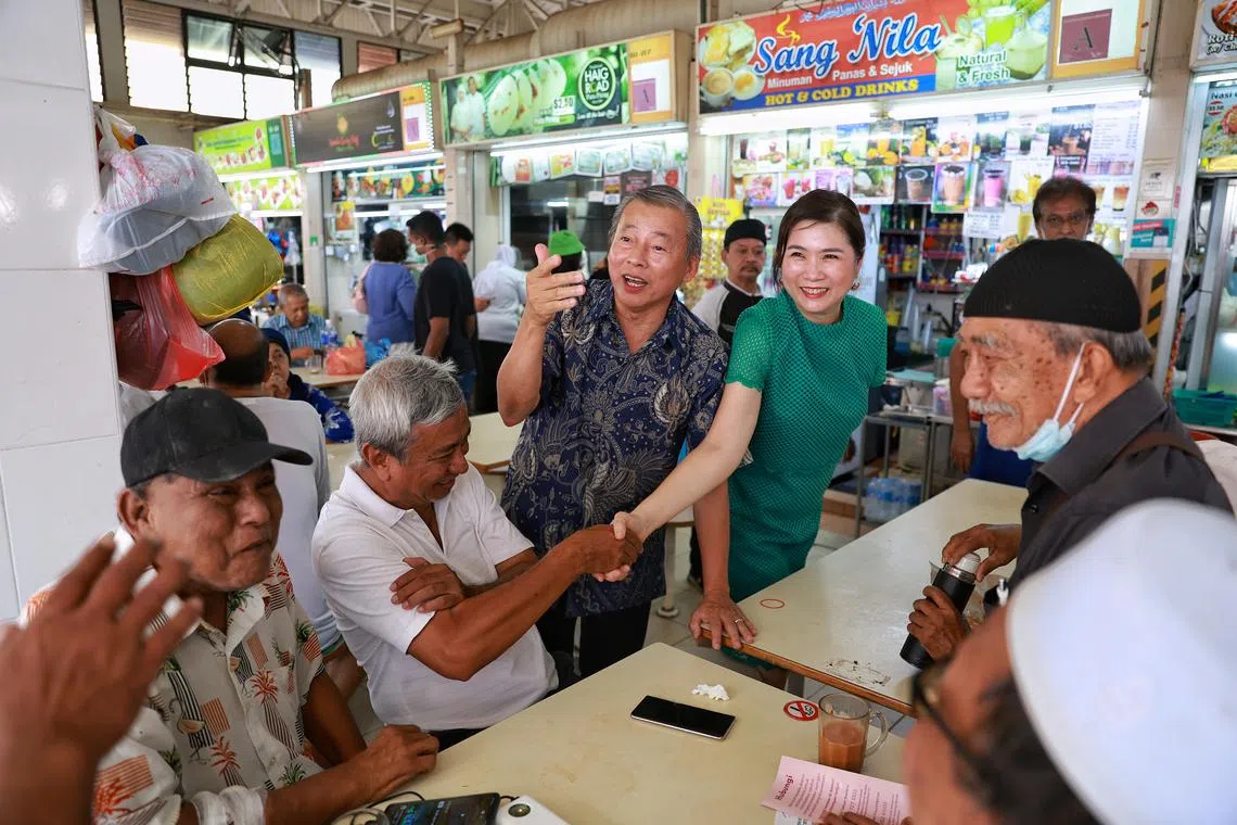 Presidential hopeful George Goh (centre), accompanied by his wife Lysa Sumali, speaking with residents at Haig Road Market and Food Centre on July 30, 2023.