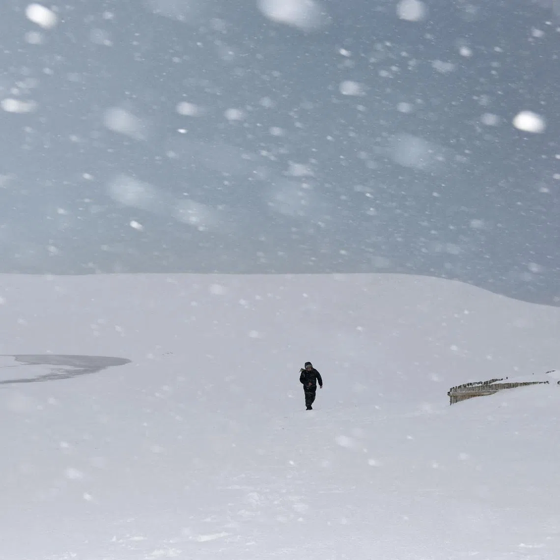 A man walks through the snowfall amid piled-up snow at the Tottori Sand Dunes in Tottori, Tottori Prefecture, Japan, on Jan 22.