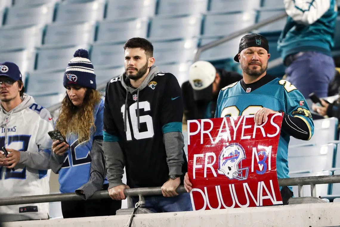 A fan holds a sign in support of Buffalo Bills safety Damar Hamlin.