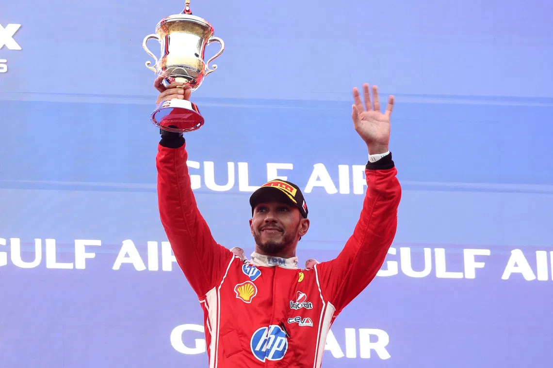 Formula One F1 - Bahrain Grand Prix - Sepang International Circuit, Sepang, Malaysia - October 4, 2026 Ferrari's Lewis Hamilton celebrates with his trophy on the podium after finishing third in the Bahrain Grand Prix REUTERS/Jakub Porzycki