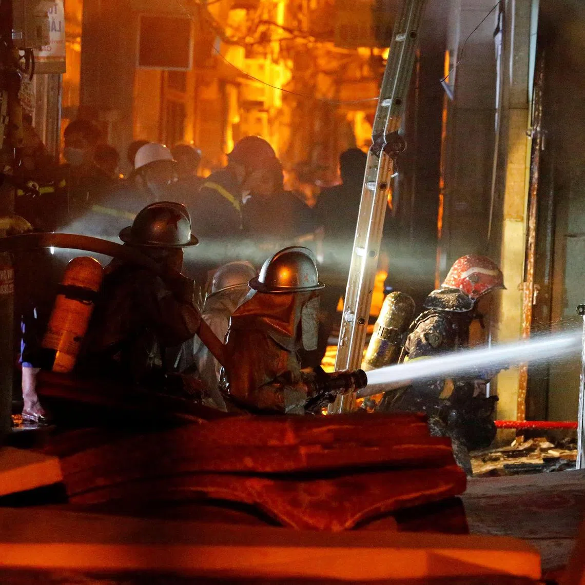 Firefighters battle a blaze engulfing an apartment block in Hanoi on Sept 13, 2023.