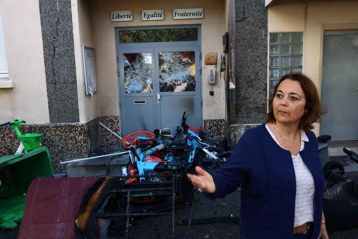 Carole Zerbib, Principal of the Lycee Vauquelin high school, in front of the damaged entrance doors of the high school with bicycles and garbage bins set on fire by protesters in Paris.