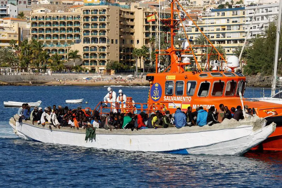 A group of migrants wait to disembark from a wooden boat after being rescued by a Spanish coast guard vessel in the port of Arguineguin, on the island of Gran Canaria, Spain, January 2, 2024. REUTERS/Borja Suarez/File Photo