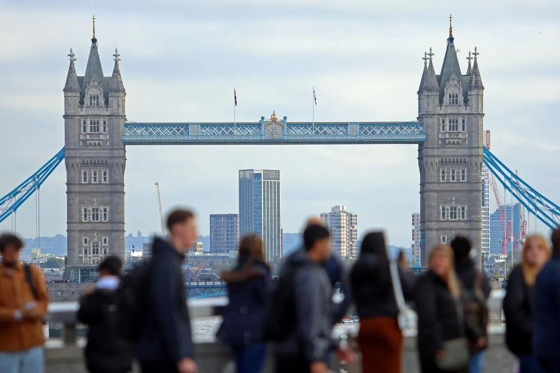 FILE PHOTO: People walk over London Bridge looking at a view of Tower Bridge in the City of London financial district in London, Britain, October 25, 2023.  REUTERS/ Susannah Ireland/File Photo