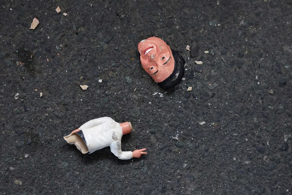 A bobblehead of Philippine President Bongbong Marcos Jr., smashed by supporters of former President Rodrigo Duterte, lying outside Villamor Airbase where Duterte is currently held after being arrested, in Pasay City, Manila, Philippines, on March 11, 2025.
