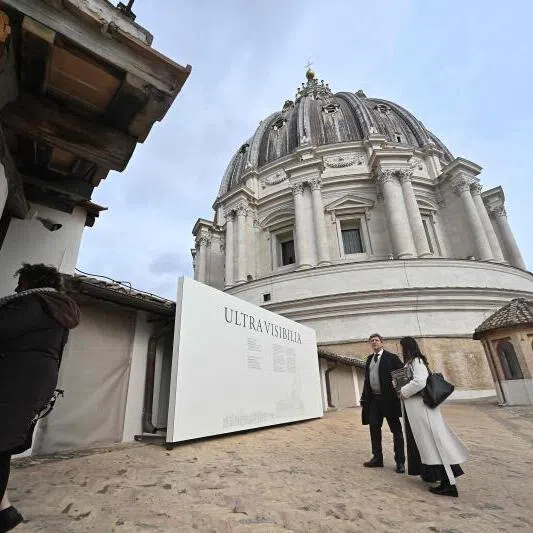People stand on a terrace of St Peter's Basilica before a press preview of the exhibition "Beyond the Visible" project, in the Vatican on Feb 16, 2026.