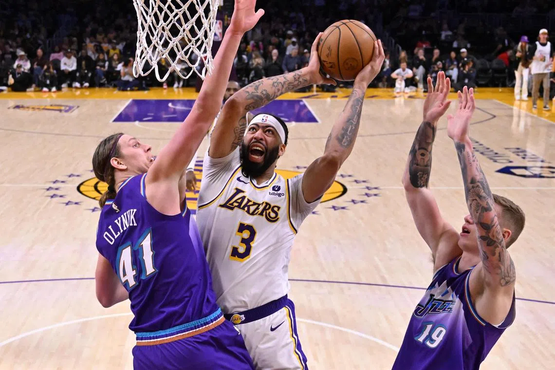 Los Angeles Lakers forward Anthony Davis grabbing a rebound in front of Utah Jazz forward Kelly Olynyk and forward Luka Samanic in the first half at Crypto.com Arena.