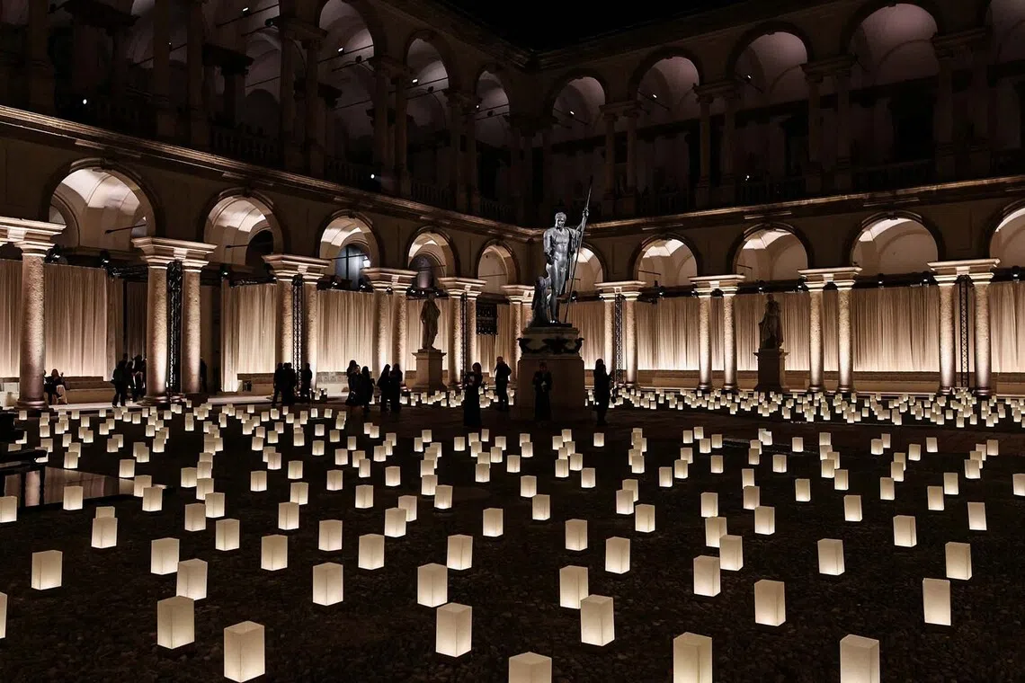 People walking by the "Napoleon as Mars the Peacemaker" statue at the end of the Giorgio Armani Spring/Summer 2026 collection show, during Fashion Week in Milan, Italy, Sept 28, 2025. 