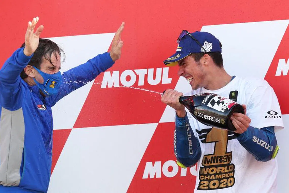 FILE PHOTO: MotoGP - Valencia Grand Prix - Circuit Ricardo Tormo, Valencia, Spain - November 15, 2020 Team Suzuki Ecstar's Joan Mir celebrates on the podium with then Suzuki Team Manager Davide Brivio after winning the world championship REUTERS/Albert Gea/File Photo