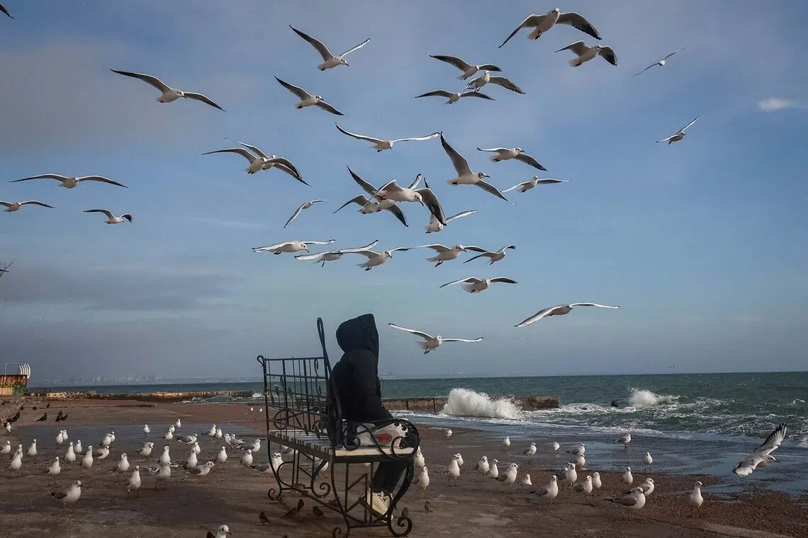 A woman sitting at the beach, amid Russia's attack on Ukraine, in the Black Sea port of Odesa, Ukraine, Nov 26, 2025. 