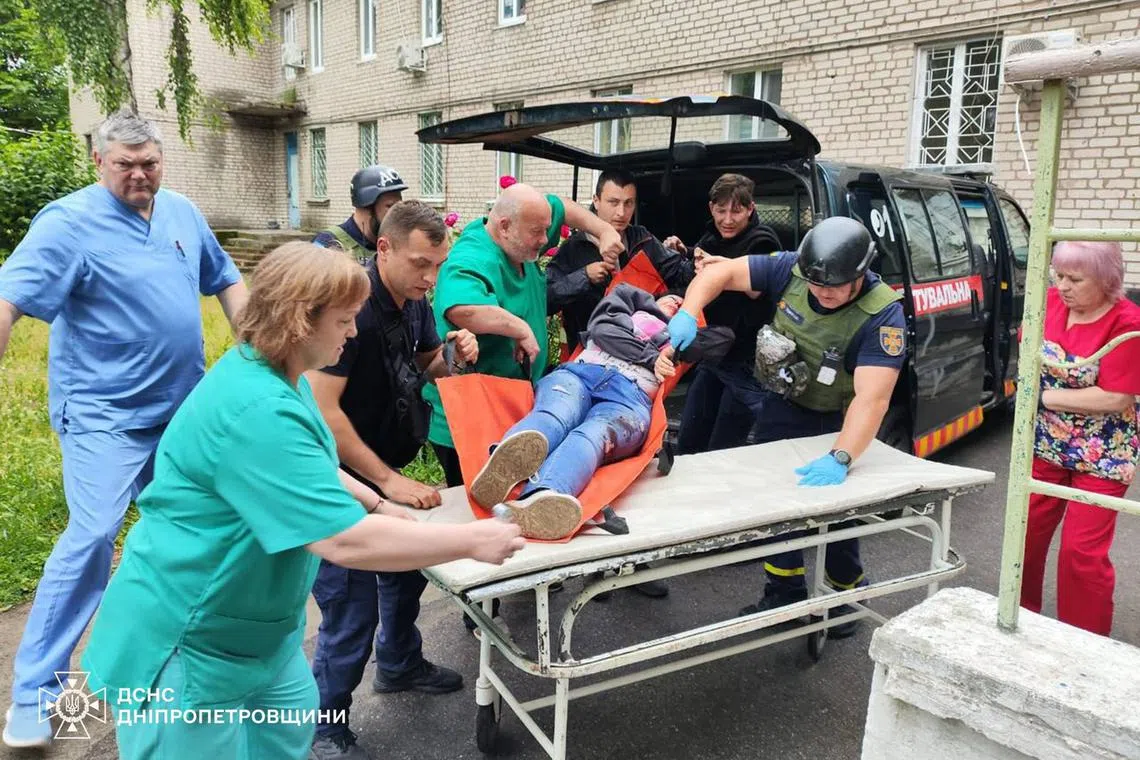 A survivor of an attack on the Ukrainian city of Nikopol - in which two people died - is helped by medical responders.