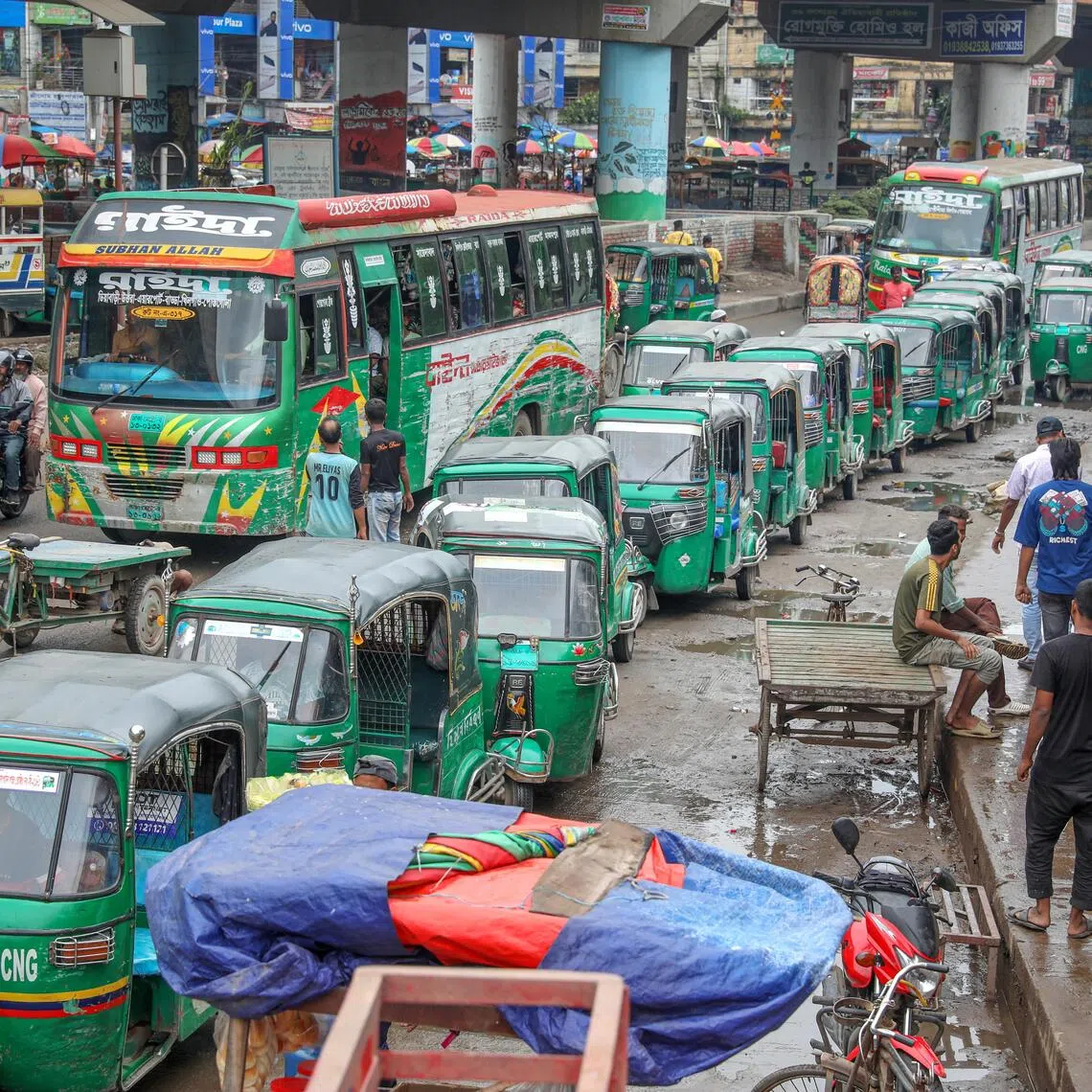 Three-wheeled auto-rickshaws that run on compressed natural gas (CNG) queue up to refuel at a filling station, in Dhaka, Bangladesh.