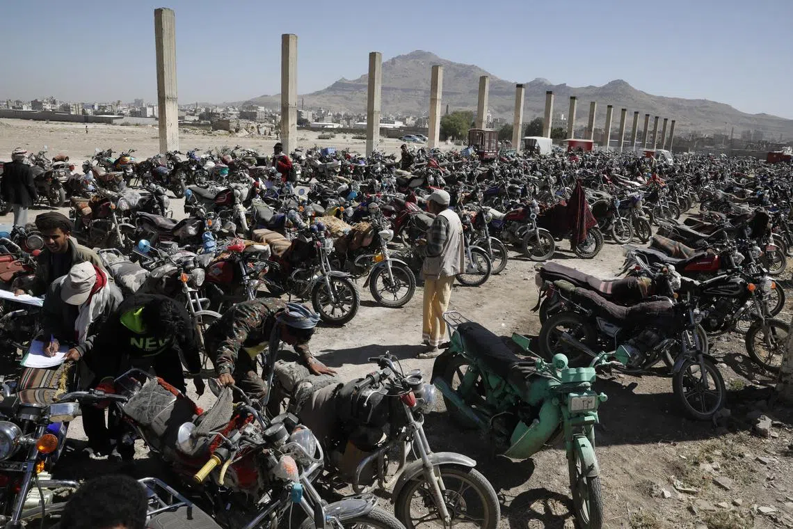 Yemeni motorcycle-taxi drivers stand next to their seized motorcycles during a security crackdown at a police center in Sana'a, Yemen on Feb 22, 2023. The Houthis-run traffic police authority in Sana'a has launched a security campaign to control vehicles and motorcycles with unregistered plates and register thousands of unlicensed motorcycles amid insecurity.  