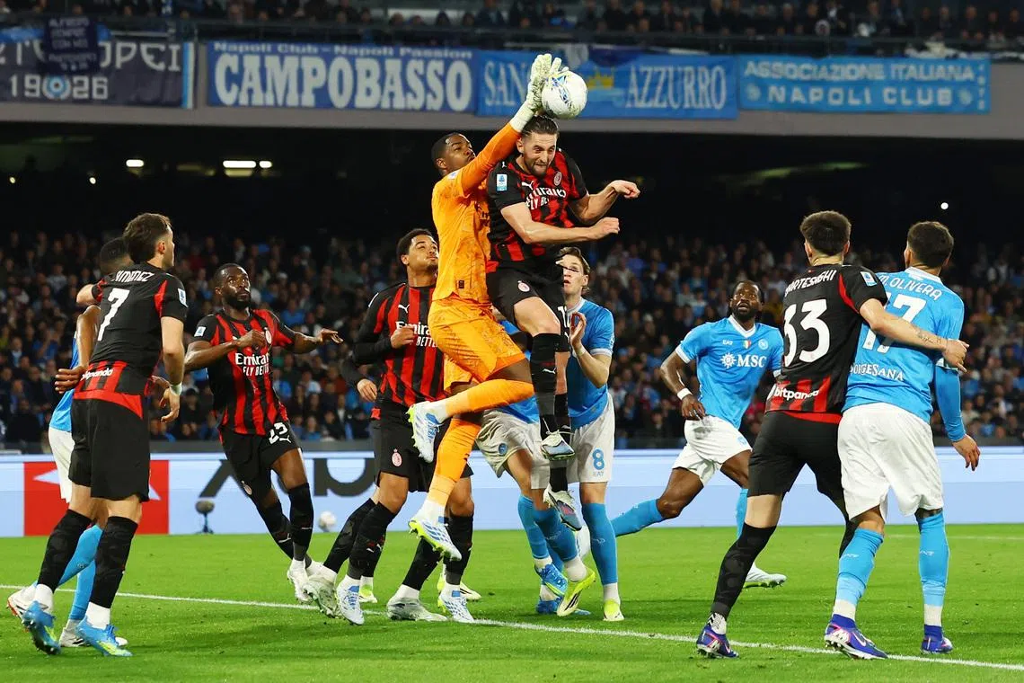 FILE PHOTO: Soccer Football - Serie A - Napoli v AC Milan - Stadio Diego Armando Maradona, Naples, Italy - April 6, 2026 AC Milan's Mike Maignan in action with Napoli's Scott McTominay and AC Milan's Adrien Rabiot. REUTERS/Ciro De Luca/File Photo