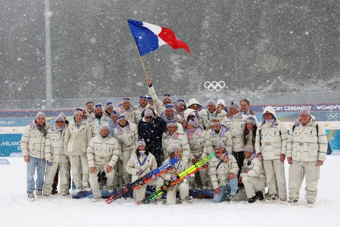 Milano Cortina 2026 Olympics - Biathlon - Women's 12.5km Mass Start Victory Ceremony - Anterselva Biathlon Arena, South Tyrol, Italy - February 21, 2026. Gold medallist Oceane Michelon of France celebrates with silver medallist Julia Simon of France and their team during the women's 12.5km mass start victory ceremony REUTERS/Matthew Childs