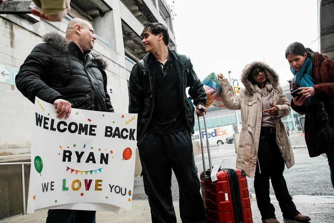 Mr Ryan Rivera speaking with his father at JFK international airport in New York on March 5, after arriving aboard a US government chartered flight.