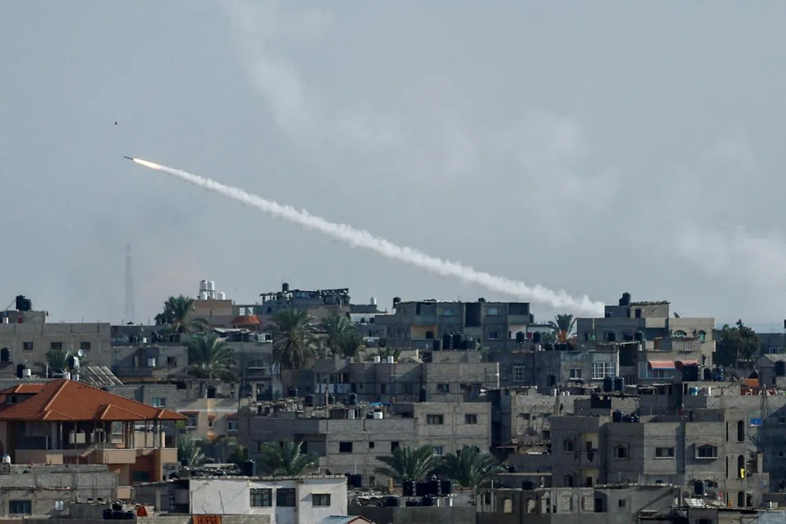 A rocket is fired from Gaza toward Israel, in Gaza, on Oct 7.