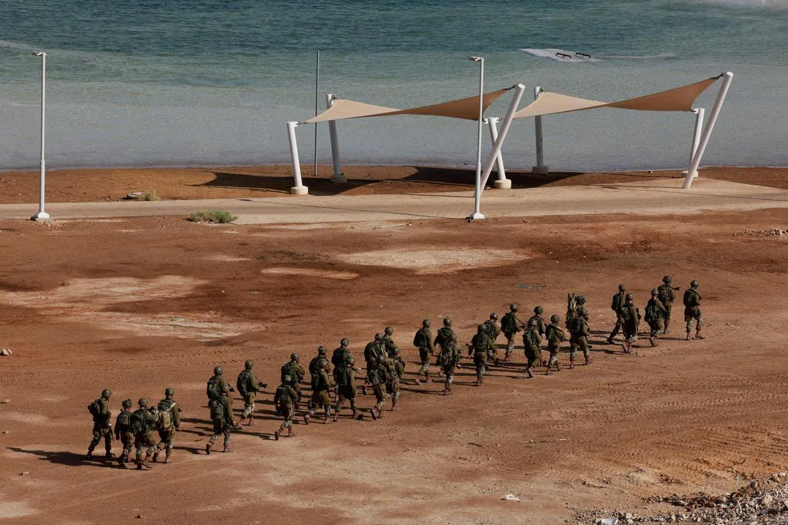 Israeli military members walk next to the Dead Sea near the scene of the shooting.