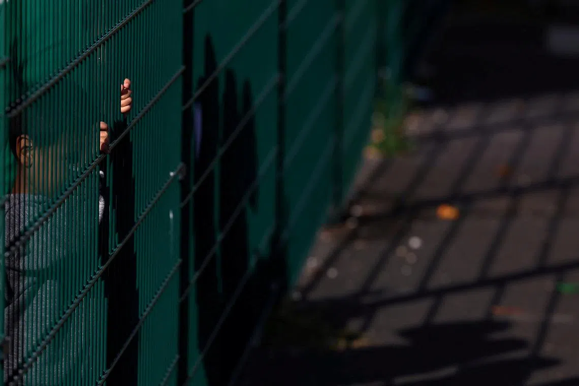A refugee child standing by the fence at the first reception center for refugees in Giessen, Germany, Oct 11,.