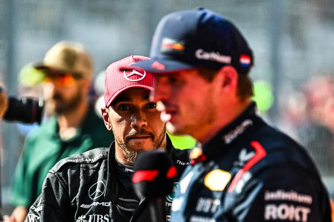 Mercedes driver Lewis Hamilton watches as Red Bull Racing's Max Verstappen is interviewed after winning the United States Formula Grand Prix at the Circuit of the Americas.