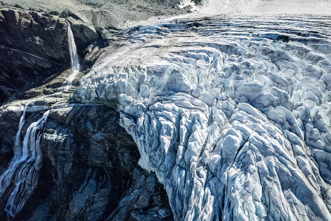 A drone view shows water from melting ice running down the side of the Turtmann glacier on a warm summer day, amid climate change, in Turtmann, Switzerland, September 3, 2025. REUTERS/Denis Balibouse