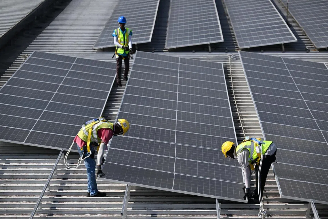 Workers installing solar panels on the roof of Changi Airport Terminal 3 on February 14.