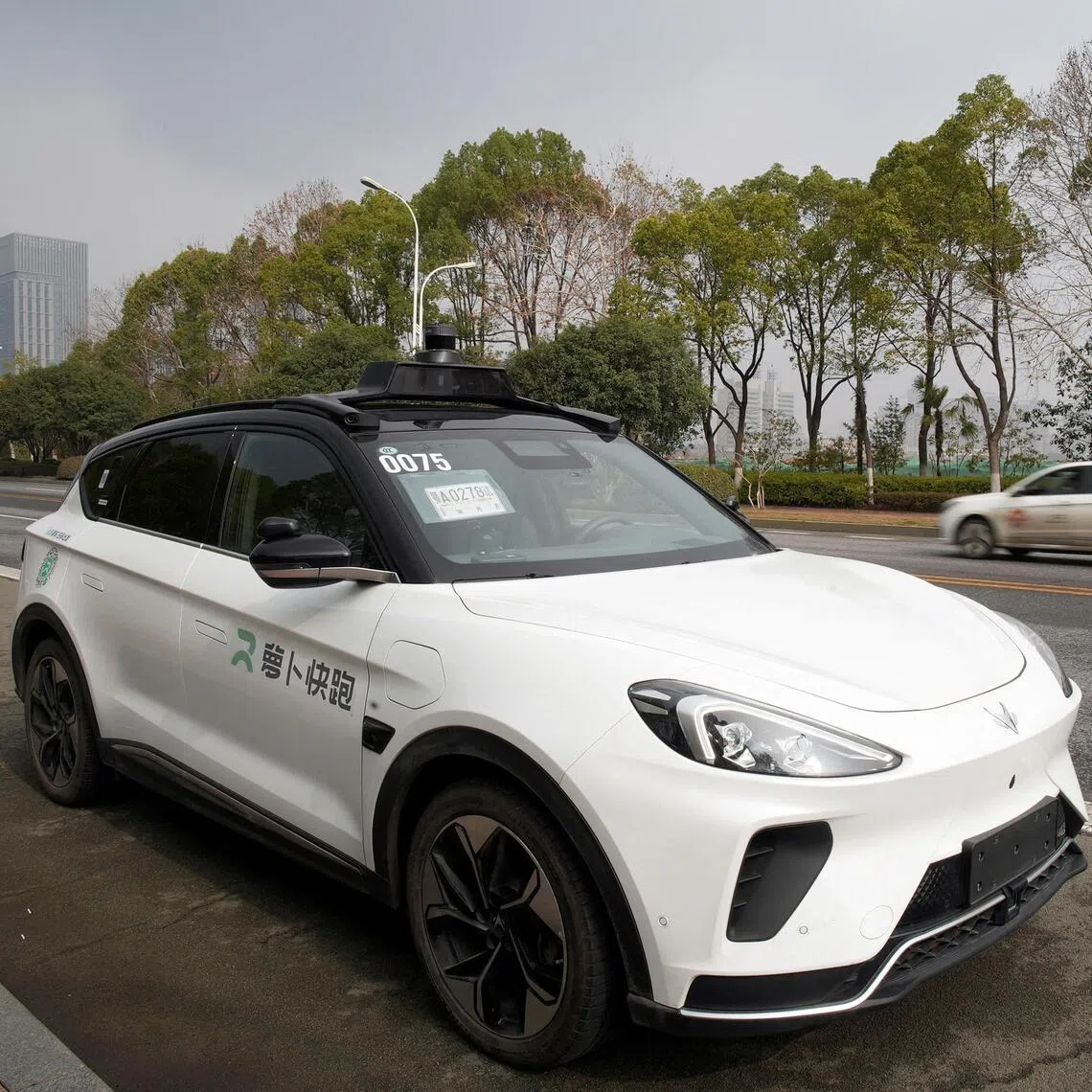 FILE PHOTO: A car of Baidu's driverless robotaxi service Apollo Go is seen on a road in Wuhan, Hubei province, China February 24, 2023. REUTERS/Josh Arslan/File Photo