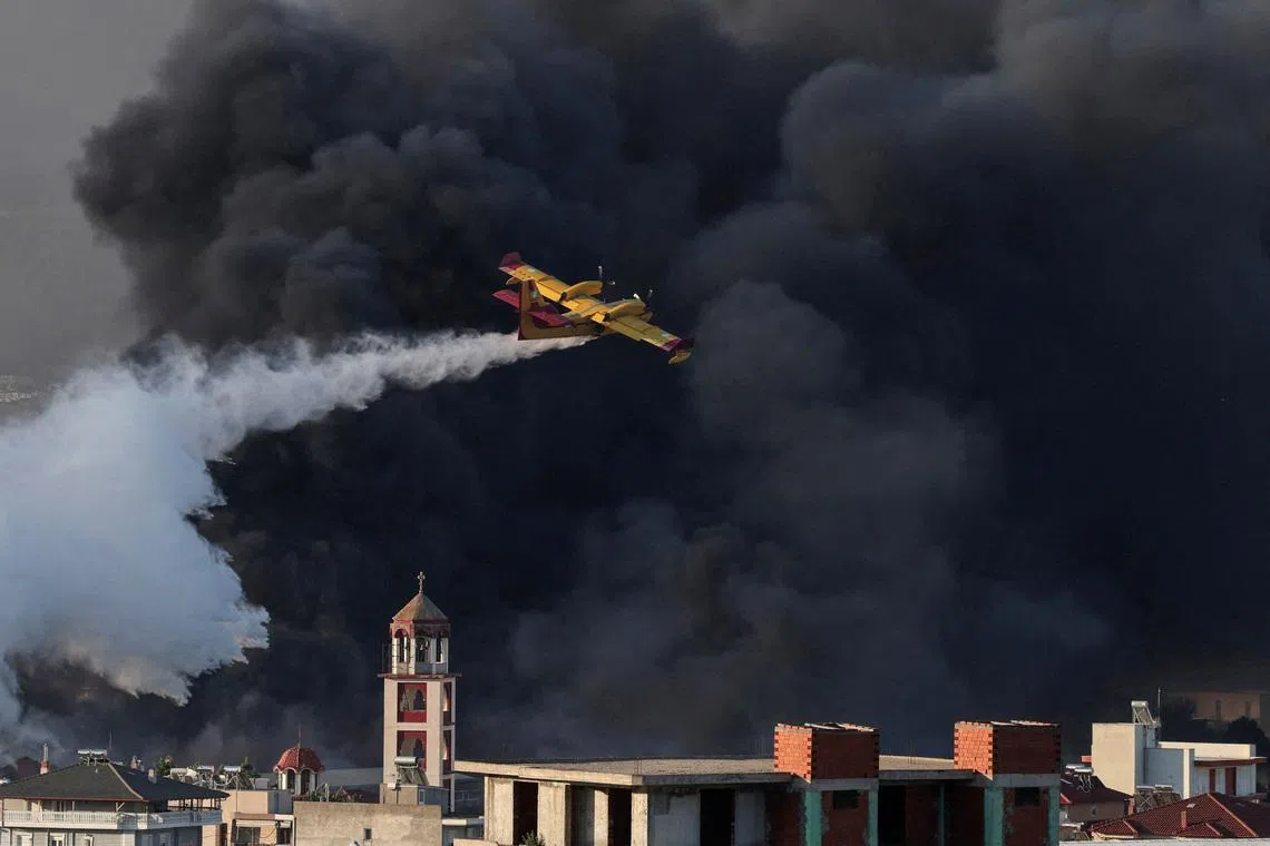 A Canadair firefighting plane drops water at a burning recycling factory in Oreokastro, on the outskirts of Thessaloniki, Greece, July 5, 2026. REUTERS/Alexandros Avramidis