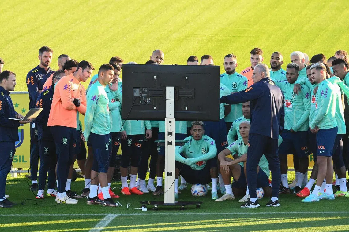 TOPSHOT - Brazil's coach Tite (Front R) gathers players and staff around a television screen during a training session on November 16, 2022 at the Continassa training ground in Turin, as part of Brazil's preparation ahead of the Qatar 2022 World Cup. (Photo by Vincenzo PINTO / AFP)