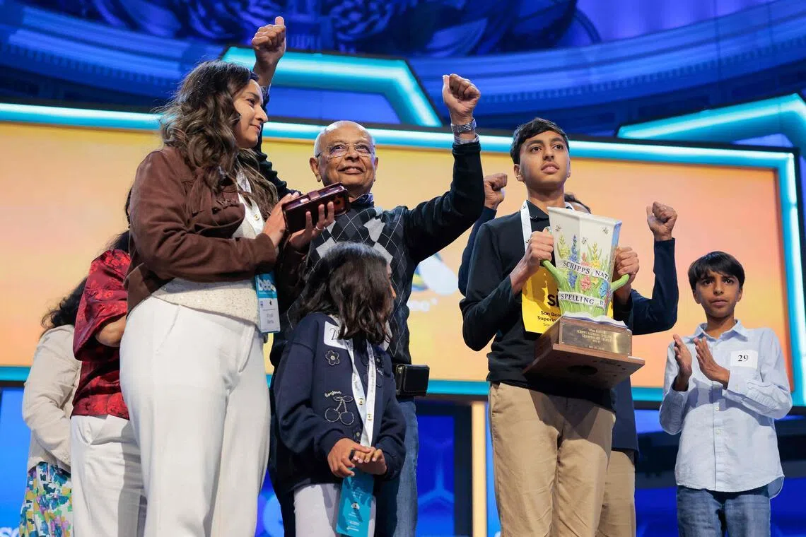 Shrey Parikh, 14, holding a trophy and celebrating with family after winning the 2026 Scripps National Spelling Bee on May 28.