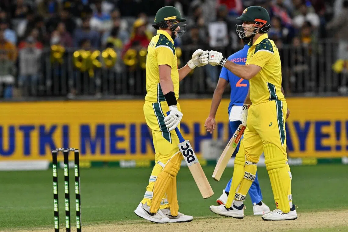 Australia's Matt Renshaw (left) and Mitchell Marsh bump fists during the first one-day international cricket match against India in Perth on Oct 19, 2025.
