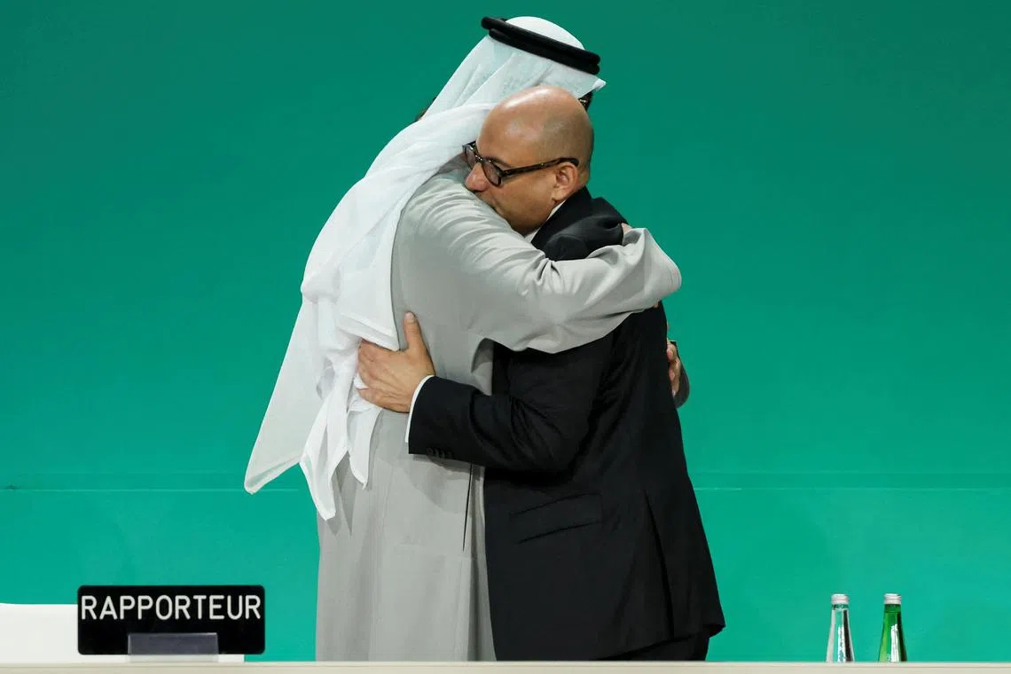 United Arab Emirates Minister of Industry and Advanced Technology and COP28 President, Sultan Ahmed Al Jaber, hugs Executive Secretary of UNFCCC Simon Stiell as they attend a plenary meeting, after a draft of a negotiation deal was released, at the United Nations Climate Change Conference COP28 in Dubai, United Arab Emirates, December 13, 2023. REUTERS/Amr Alfiky