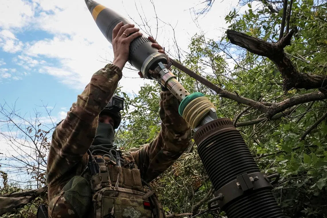 A Ukrainian serviceman prepares to fire a mortar at Russian front-line positions near Bakhmut, in Ukraine's Donetsk region.