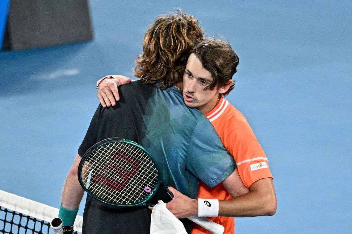 Australia's Alex De Minaur (right) receives a consoling hug from Andrey Rublev after the match.