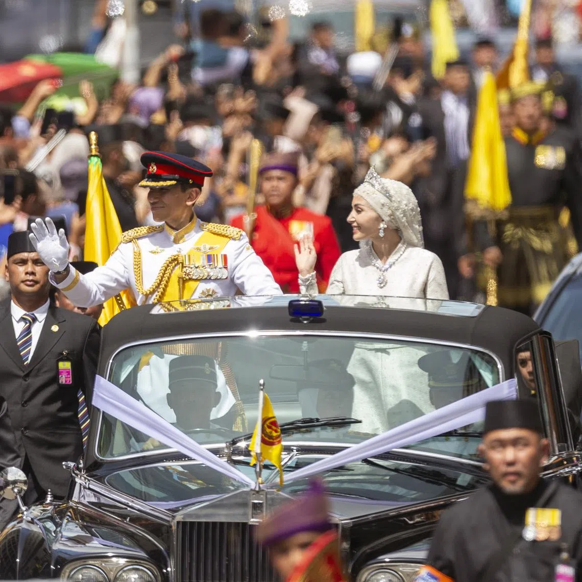 The newlywed royal couple Prince Abdul Mateen and his bride Anisha Rosnah greeting the crowd from a royal vehicle during the street procession of the royal wedding ceremony in Bandar Seri Begawan, Brunei, on Jan 14, 2024. 