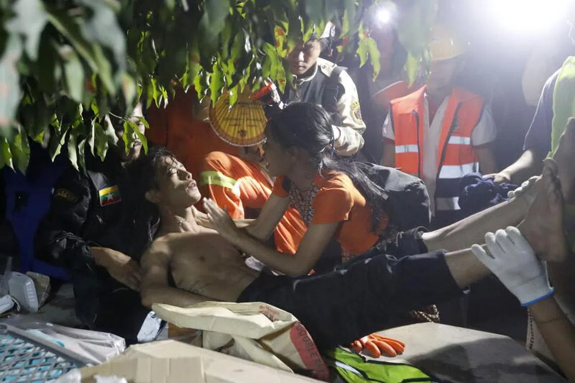 epa11999817 A health worker helps a fainted rescuer at the Sky Villa in Mandalay, Myanmar, 30 March 2025. More than 1,600 people have been killed and thousands injured after a 7.7-magnitude earthquake struck the country on 28 March, according to the Myanmar government. EPA-EFE/NYEIN CHAN NAING