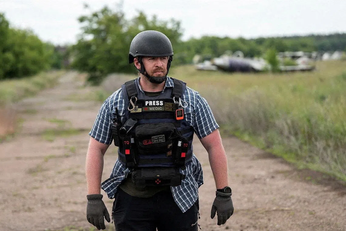 Reuters safety advisor Ryan Evans stands in a field while working with a news reporting team in an undated photo taken in Ukraine. REUTERS/Staff