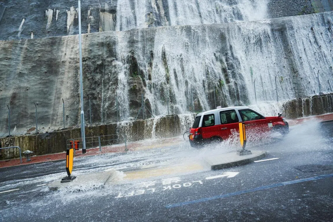 A taxi driving past a flooded area during heavy rains, in Hong Kong, China, on July 29, 2025.