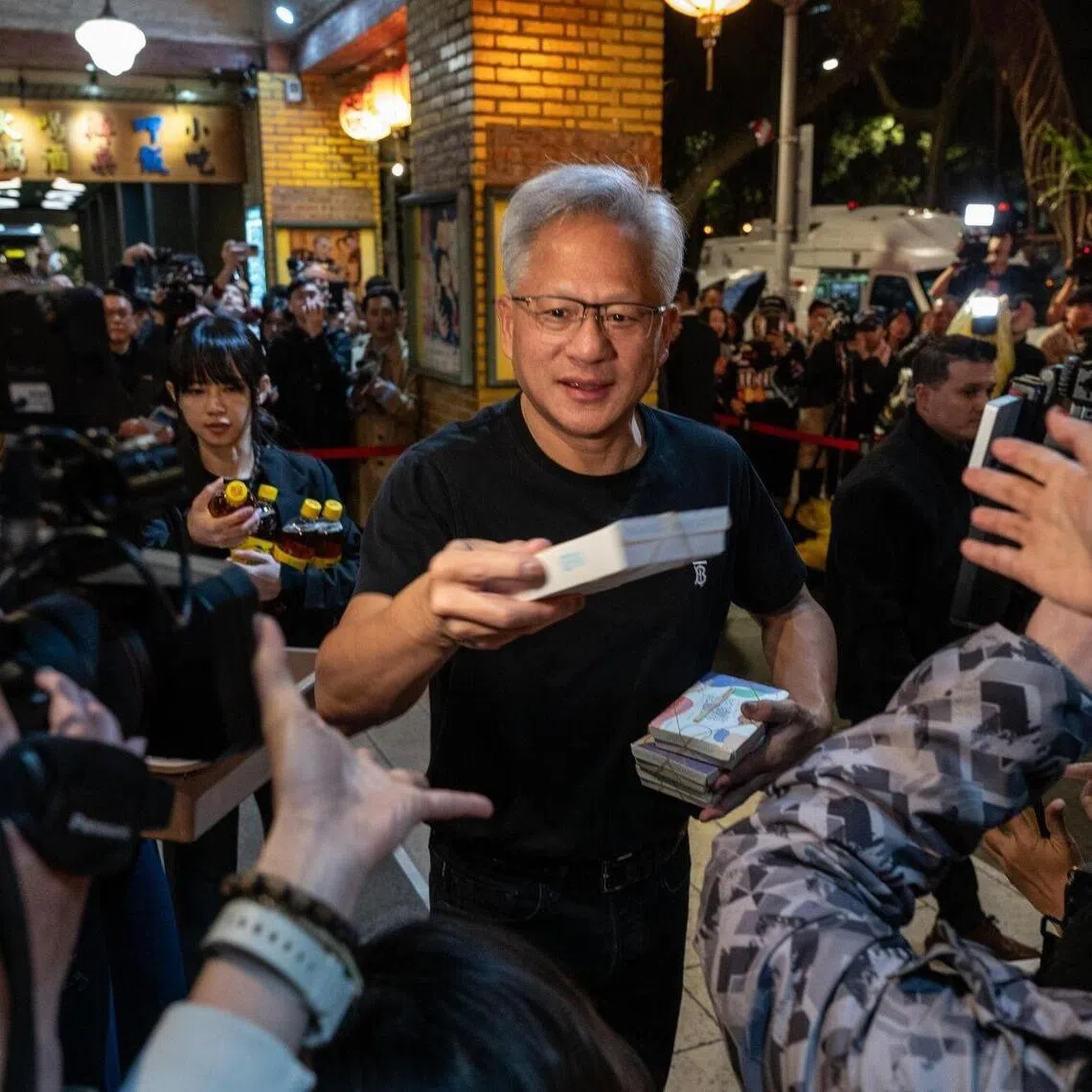 Nvidia Corp chief executive officer Jensen Huang hands out food to supporters on Jan 31, 2026, during a dinner event with the company's Taiwanese suppliers in Taipei, Taiwan.