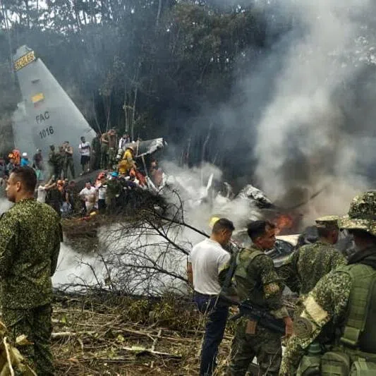 Soldiers and rescuers near an Air Force Hercules emitting thick smoke after the aircraft crashed during takeoff in Puerto Leguizamo, Colombia, near the southern border with Ecuador, on March 23, 2026.